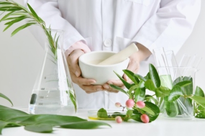 Mörser mit Kräutern und pflanzlichen Bestandteilen alternativer Medizin